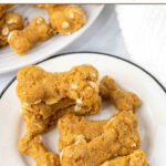 Homemade bone-shaped ground turkey dog treats on plates.
