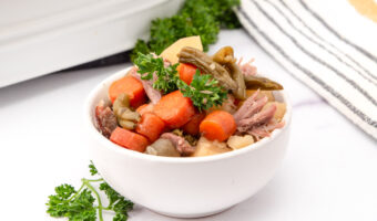 Homemade lamb stew for dogs with potatoes, carrots, green beans, and curly parsley.