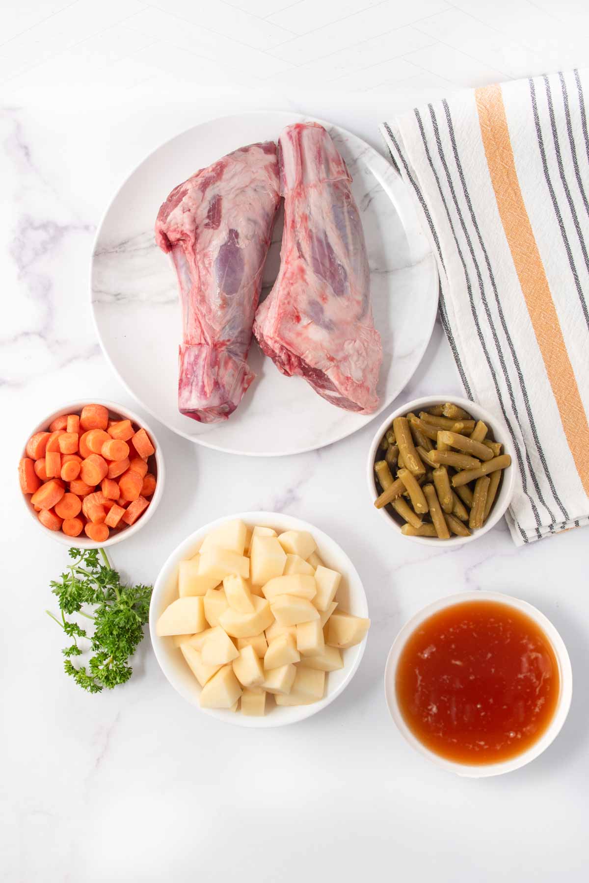 Homemade lamb stew for dogs ingredients on a marble surface.