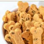 Homemade bone-shaped Thanksgiving dog treats in a bowl.