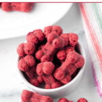 Homemade beet dog treats in a beside a small bowl.