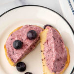 A homemade blueberry pie for dogs cut in half on a plate.