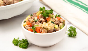 Homemade ground lamb dog food garnished with fresh curly parsley.