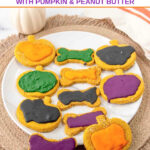 Bone and pumpkin-shaped homemade Halloween dog treats on a platter.