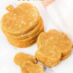 Pumpkin and paw-shaped homemade pumpkin spice dog treats in stacks.