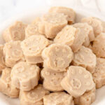 A bowl of paw-shaped homemade tuna dog treats.