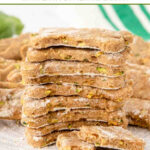 A stack of homemade bone-shaped zucchini dog treats stacked on a plate.