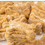 Homemade bone-shaped zucchini dog treats on a plate.