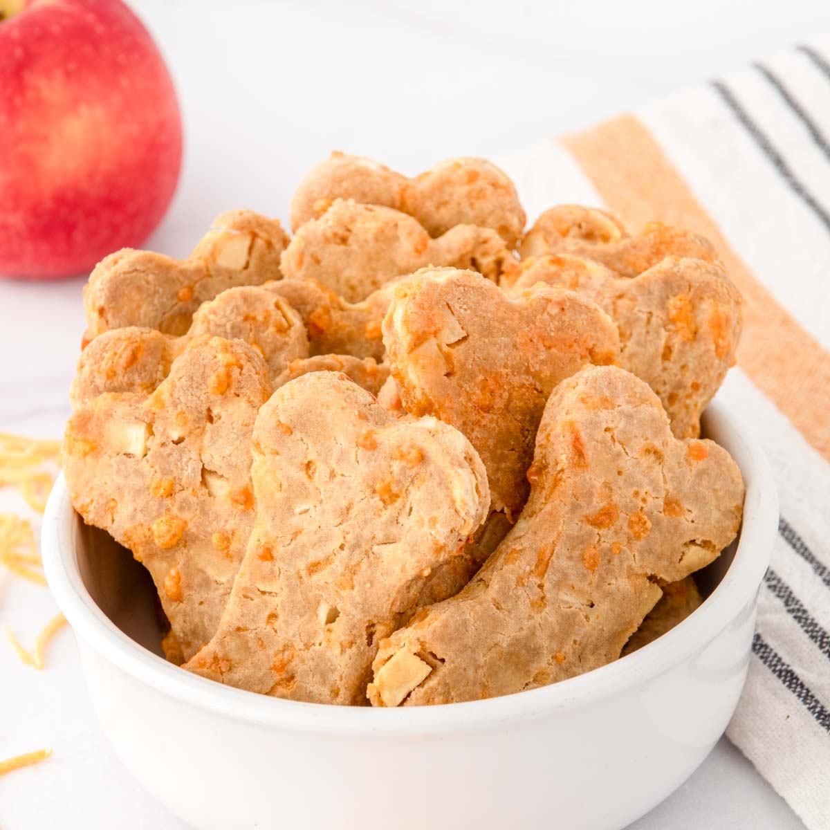 Homemade apple cheddar dog treats in a bowl.