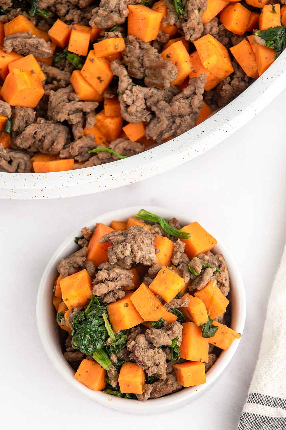 Homemade ground beef and sweet potato dog food in a small bowl and skillet.