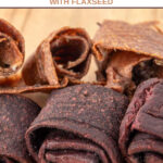 Two flavors of homemade fruit leather dog treats on a wood board.