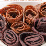 Two flavors of homemade fruit leather dog treats in a bowl.