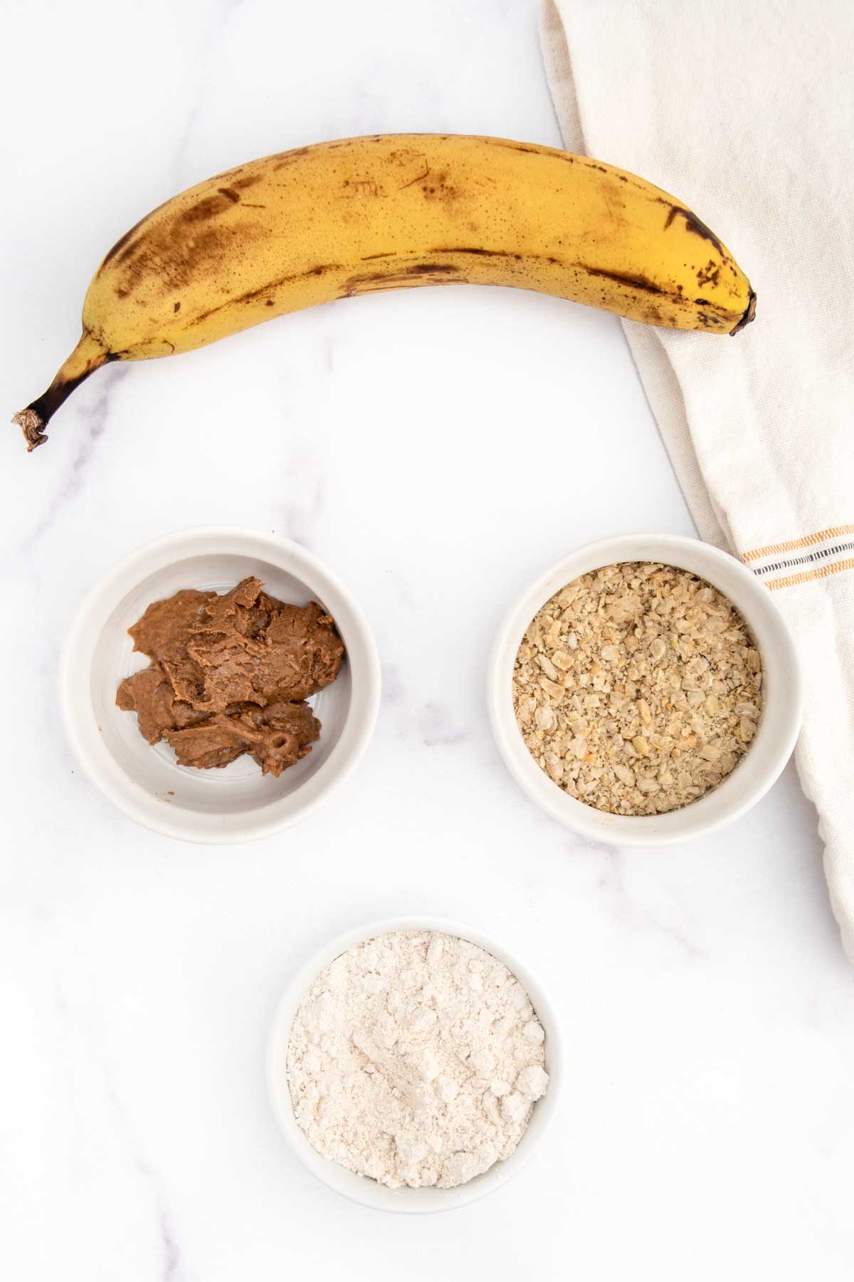 Homemade sunflower seed dog treats ingredients on a marble surface.