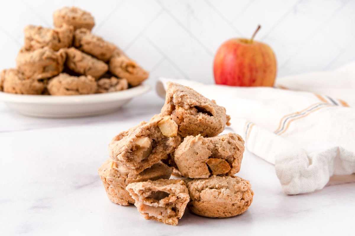 Homemade apple muffins for dogs in a small pile and on a plate.