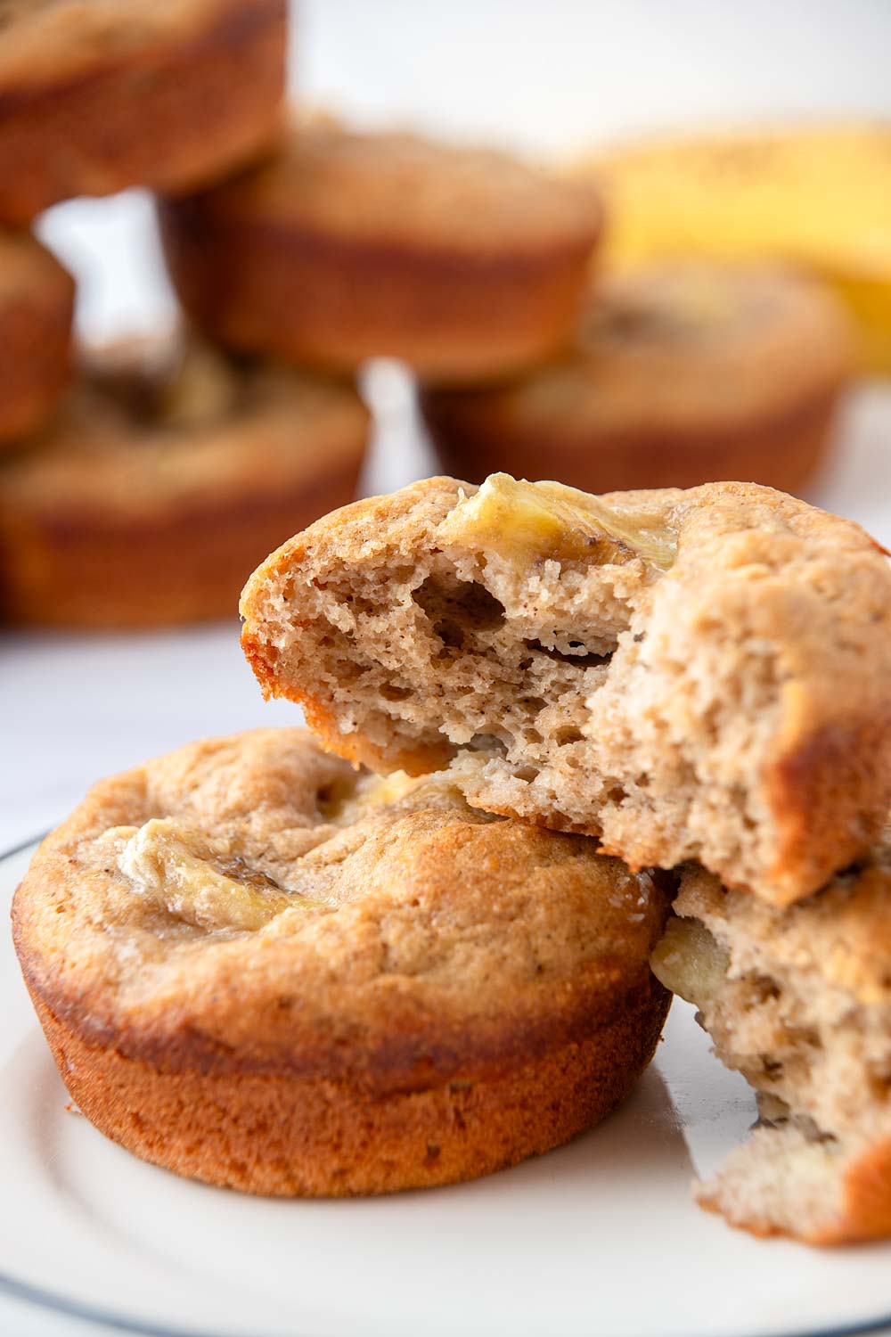 Homemade banana muffins for dogs on a small plate and in a stack.