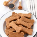 A bowl of homemade bone-shaped molasses dog treats.