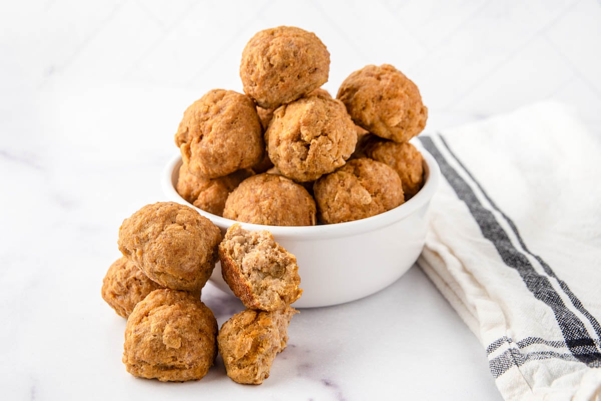 Homemade turkey pumpkin meatballs for dogs in a small bowl and beside it.