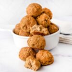 Homemade turkey pumpkin meatballs for dogs in front of and in a bowl.