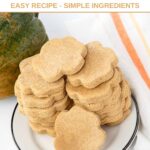 Homemade paw-shaped acorn squash dog treats on a small plate.