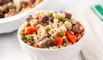 Homemade beef and barley dog food in a bowl and skillet.