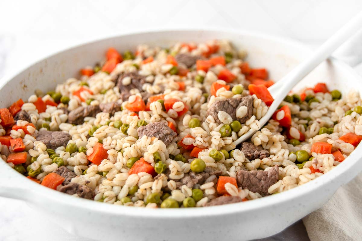 Homemade beef and barley dog food cooked in a skillet.