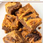 Several homemade carob peanut butter pumpkin swirl brownies on a plate.