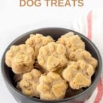 A bowl of homemade goat milk dog treats on a marble surface.