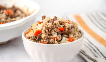 Homemade ground lamb and barley dog food in a bowl and skillet.