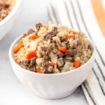 Homemade ground lamb and barley dog food in a small bowl.