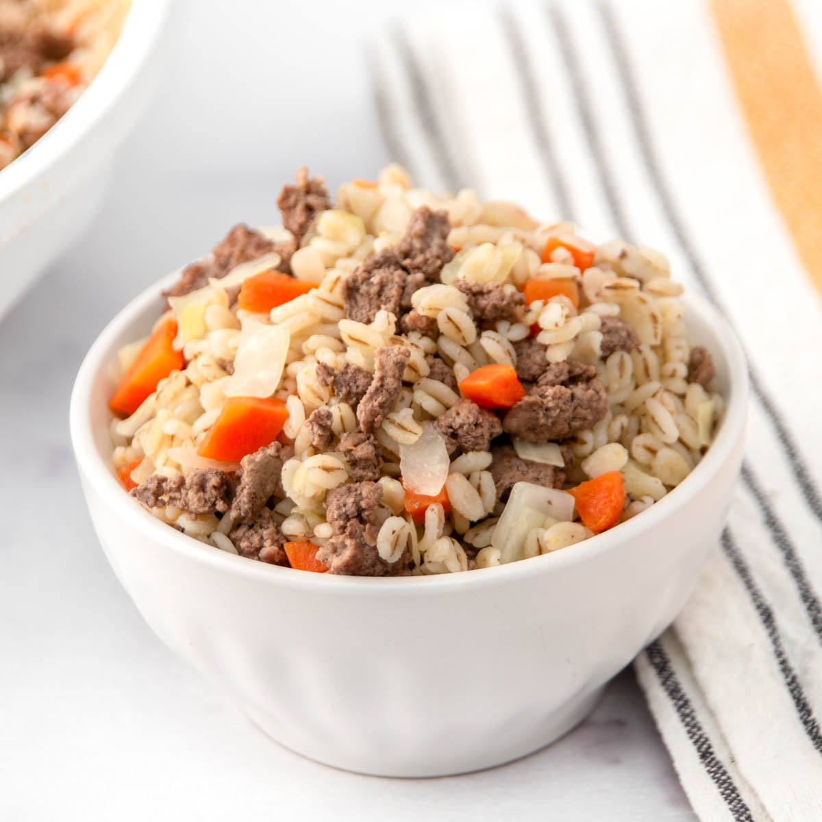 Homemade ground lamb and barley dog food in a small bowl.