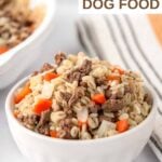 Homemade ground lamb and barley dog food in a small bowl and kitchen towel next to it.