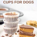Homemade peanut butter cups for dogs stacked on a plate and one cut in half.