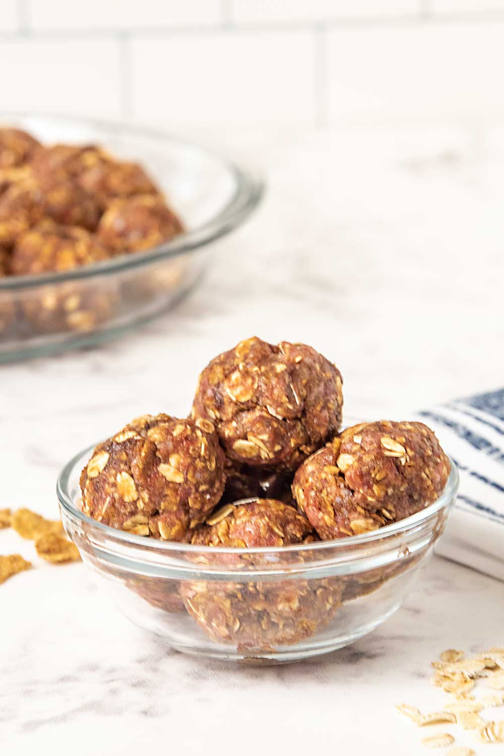Satin balls for dogs in a glass bowl and in a pie plate behind it.