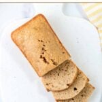 A partially sliced loaf of homemade banana bread for dogs on a cutting board.