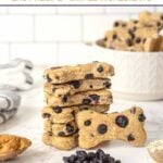 Homemade blueberry dog treats in a stack and a bowl on a marble surface.