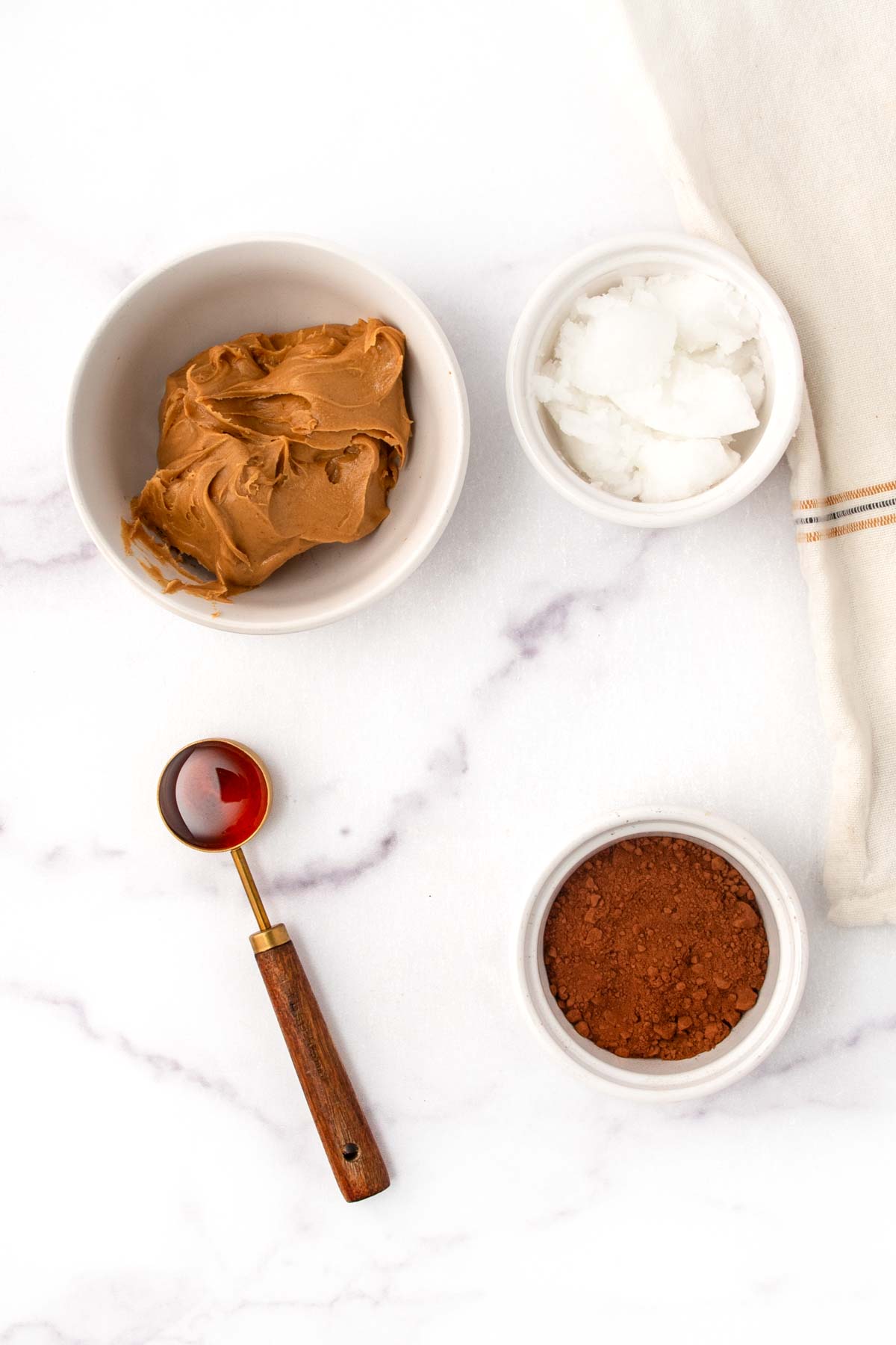 Homemade carob peanut butter candy for dogs ingredients on a marble surface.