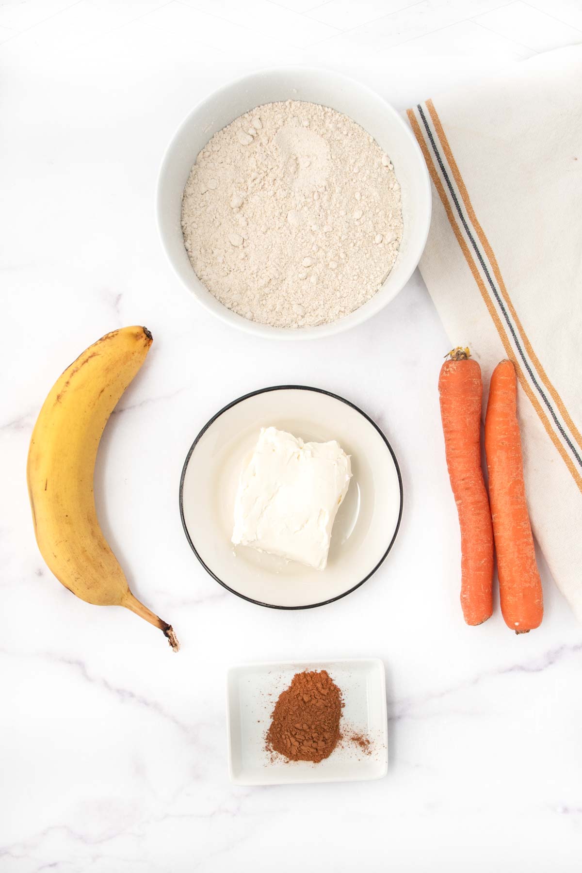 Homemade carrot cake dog treats ingredients on a marble surface.