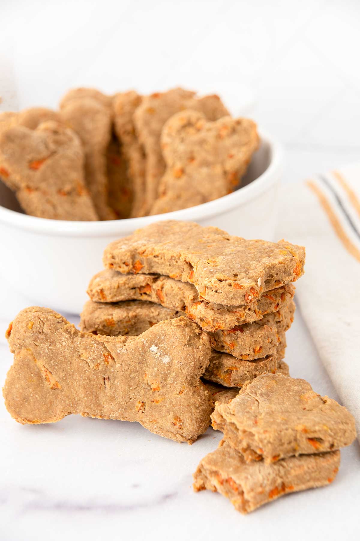 Homemade carrot cake dog treats in a stack and in a small bowl.