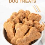 A bowl of homemade bone-shaped carrot cake dog treats.