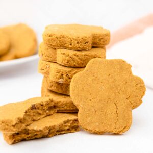 Homemade pumpkin ginger dog treats on a marble surface.