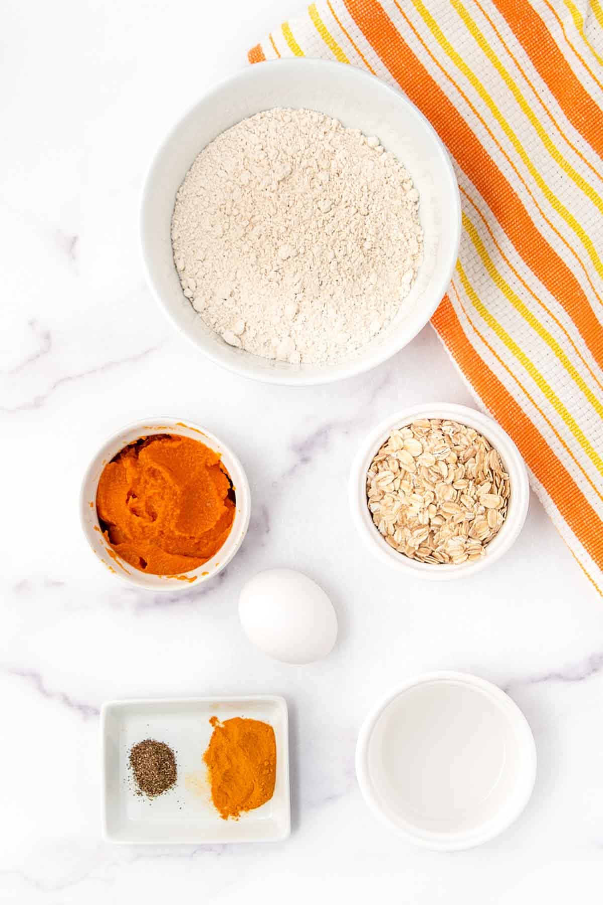 Homemade turmeric dog treats ingredients on a marble surface.