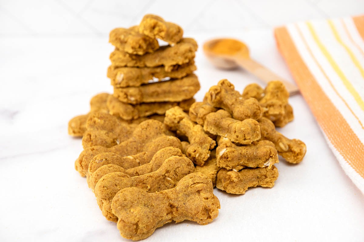 A bunch of homemade turmeric dog treats on a marble surface.