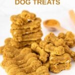 A bunch of homemade bone-shaped turmeric dog treats and turmeric in a wooden spoon.