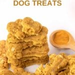Homemade bone-shaped turmeric dog treats and turmeric in a wooden spoon.