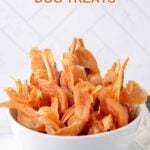 Homemade chicken wrapped sweet potato dog treat chews in a small bowl.