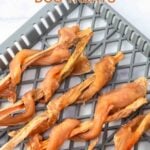 Chicken wrapped sweet potato dog treats on a dehydrator tray.