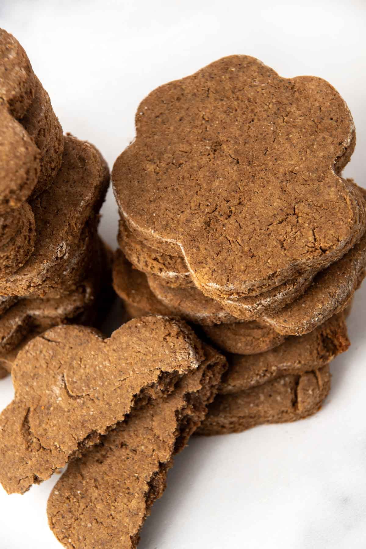 Stacks of paw-shaped homemade cricket protein treats for dogs.