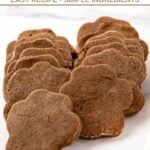 Paw-shaped homemade cricket protein dog treats on a marble surface.