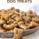 Homemade liver dog treats in a large bowl and two in front of it.