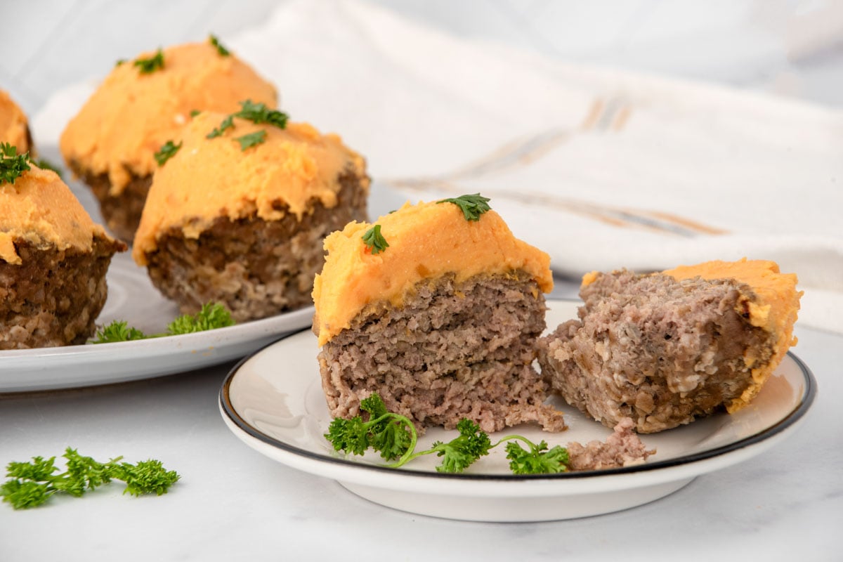 Meatloaf cupcakes topped with sweet potato frosting and garnished with curly parsley.